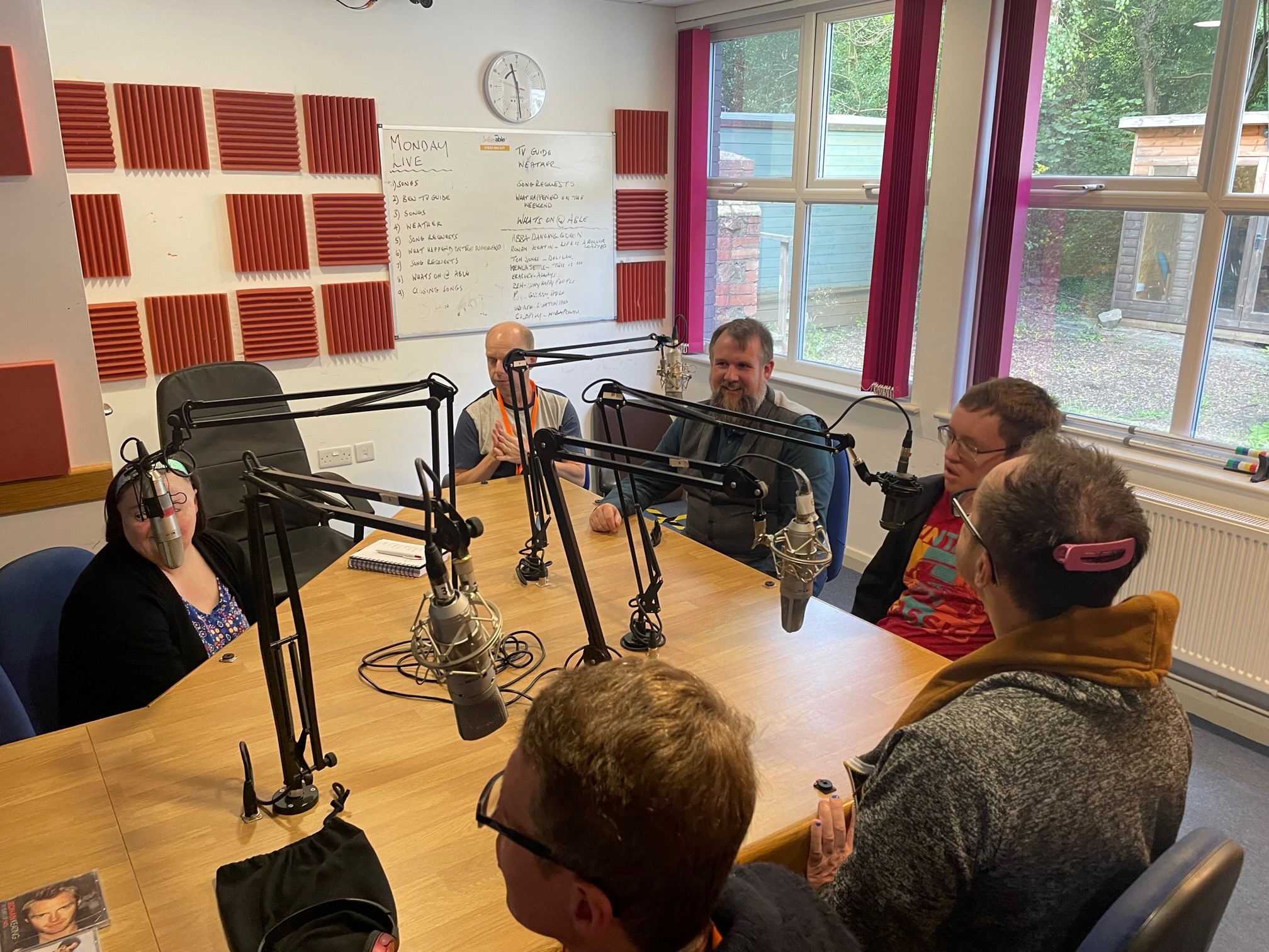 a table of six people sat with radio mics in front of them