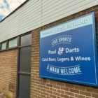 sign on wall of a pub saying pool, darts, cold beer, lagers and wines