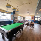 a pool table and table and. chairs in a pub