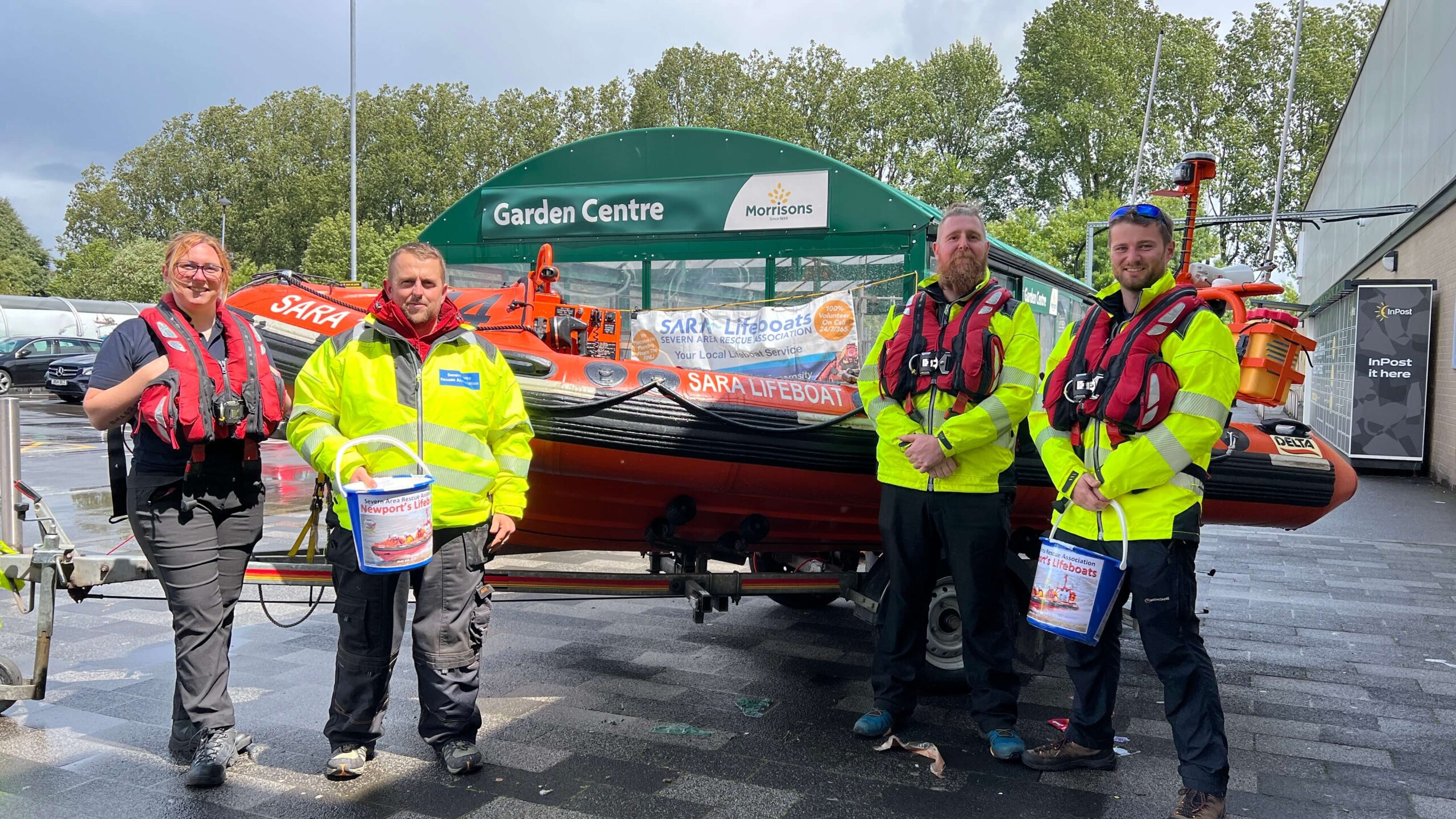 four lifeboat volunteers stood by a boat