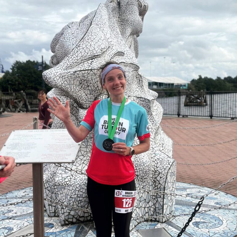 Rhian Maloney holding her medal after finishing the 50 mile route