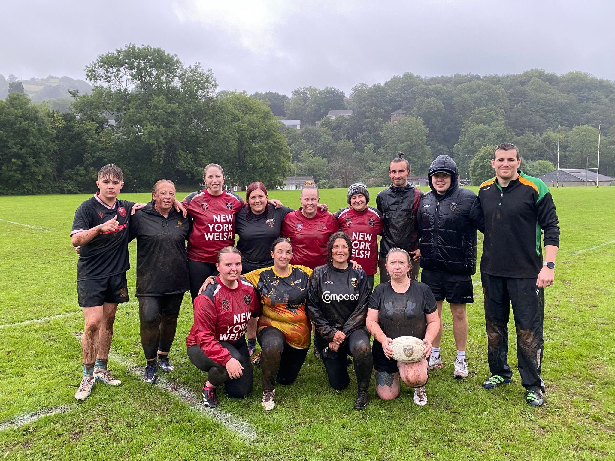 a mixed male and female rugby team pose for a photo