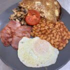 a cooked breakfast, beans, egg bacon and toast