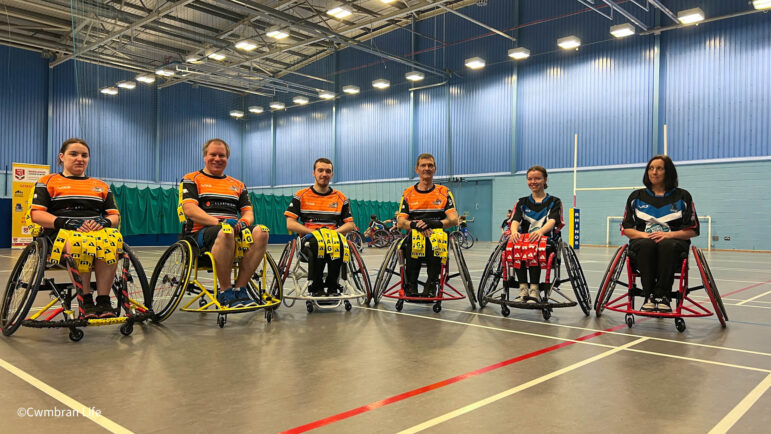 six wheelchair rugby players line up for a photo