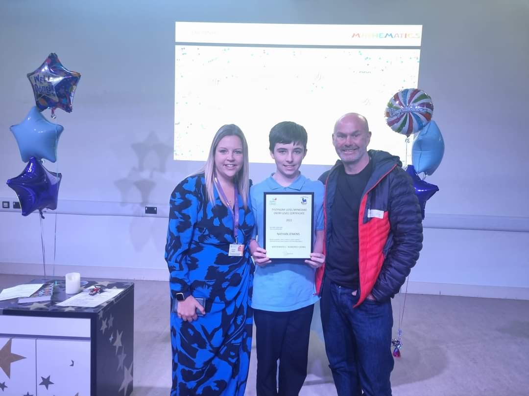 a mum and dad with their son holding a certificate