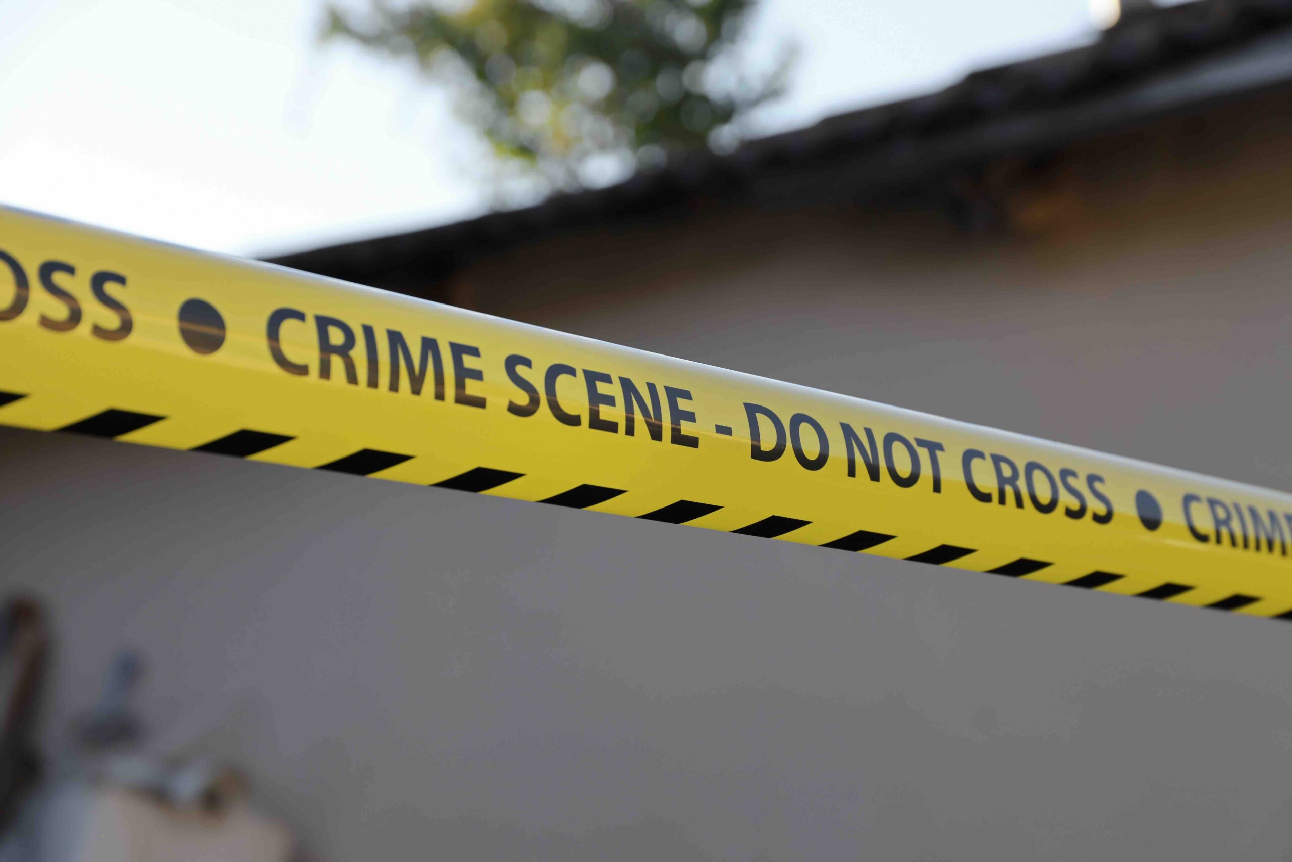 police tape across a crime scene saying don't cross