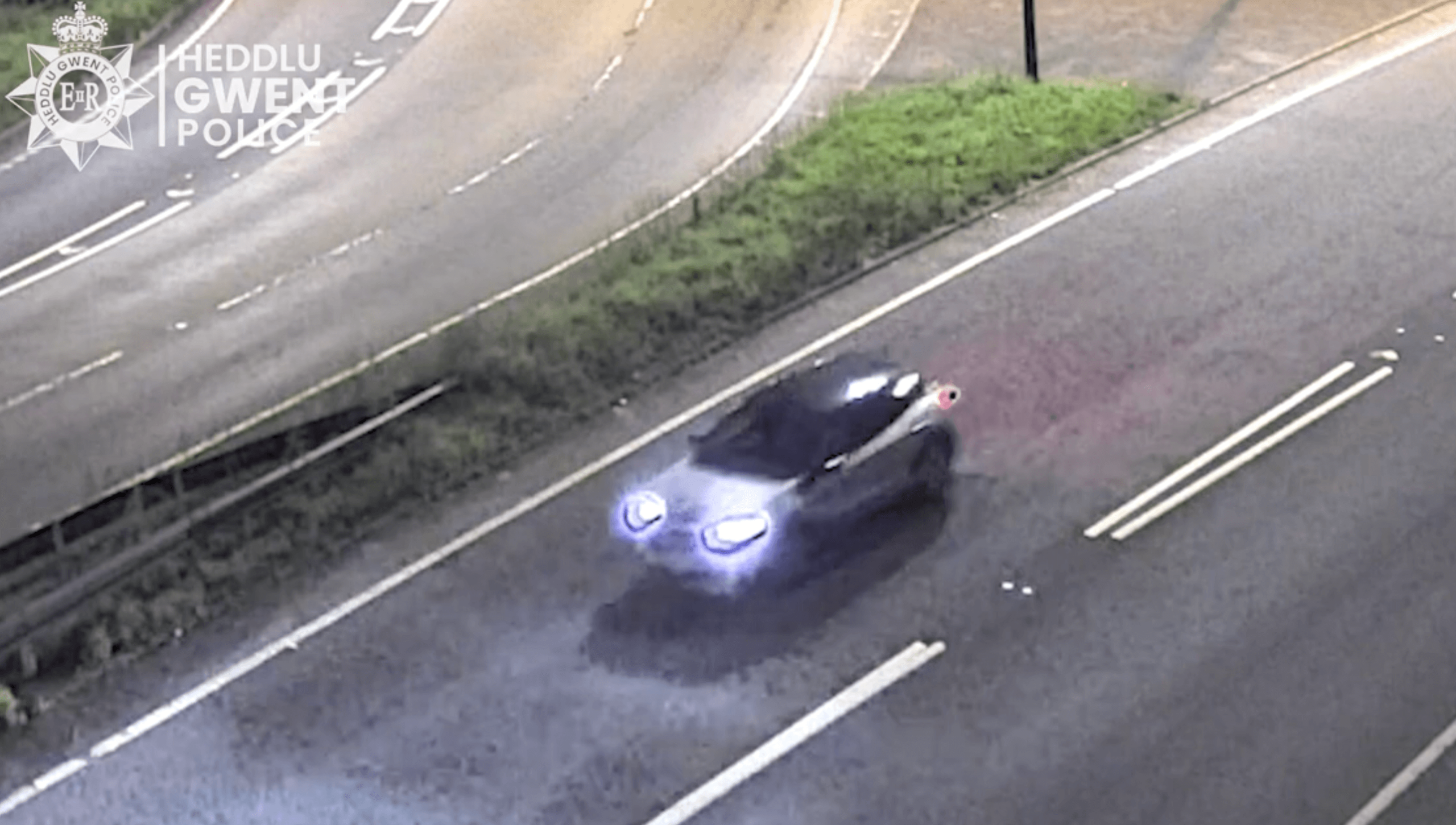 cctv image of a car driving at night
