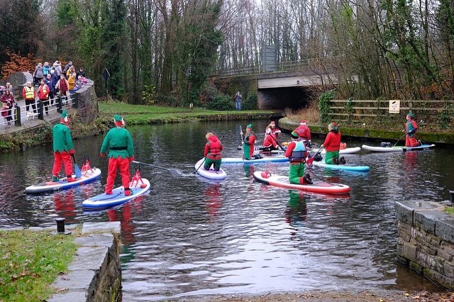 people dressed as elves on paddleboards