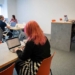 four people working on laptops in a room