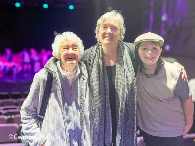 a boy with his grandmother and great-grandmother at a theatre
