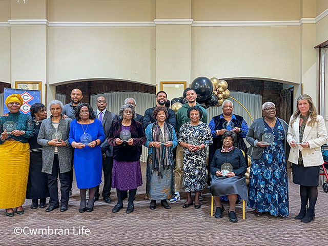 a group of people holding glass trophies