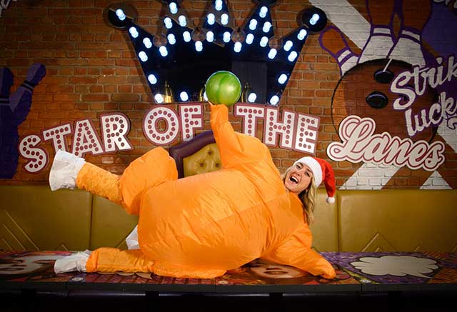 a woman dressed as a turkey in santa hat