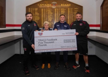 four people hold a large cheque