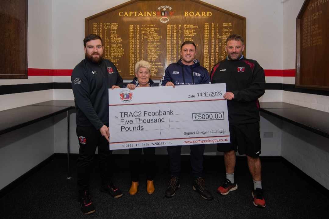 four people hold a large cheque