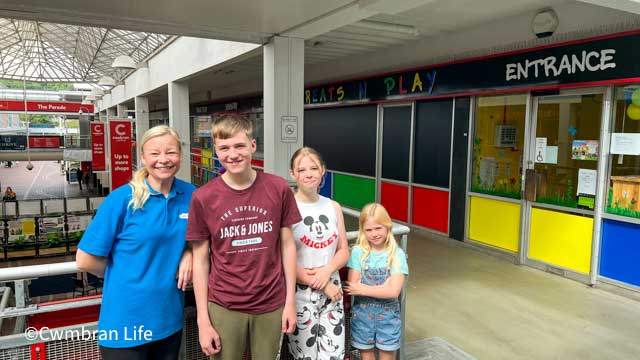 a woman and her three children smile for a photo