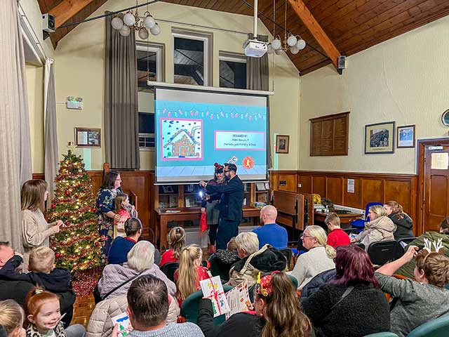 a child is given an award in front of roomful of people