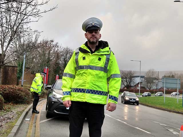 a police officer stood by a road