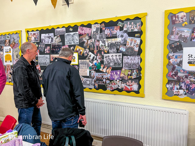 two people view a wall of photos