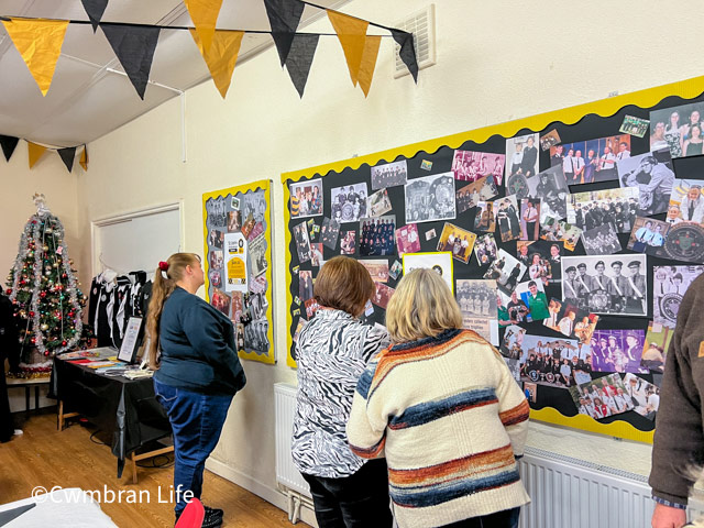 three people view a wall of photos