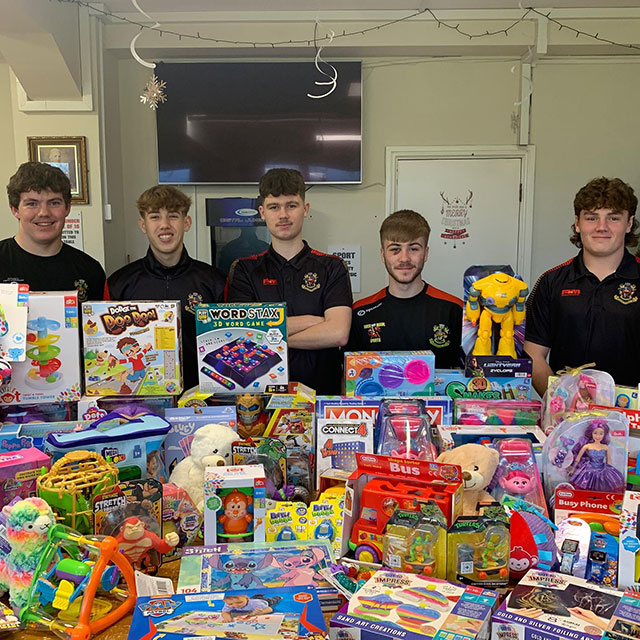 five youth rugby players stood by a lot of toys