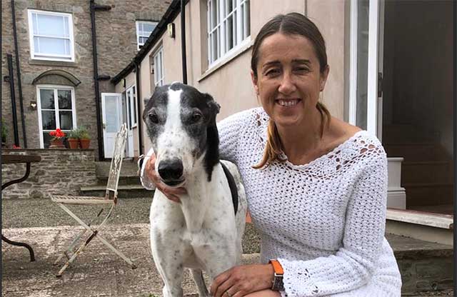 a woman with her greyhound dog