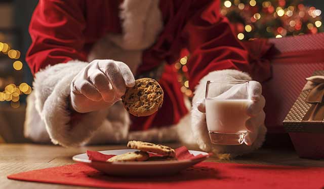 santa grabbing a cookie and drinking milk