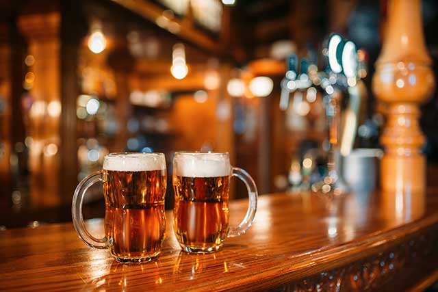 two beer glasses on bar