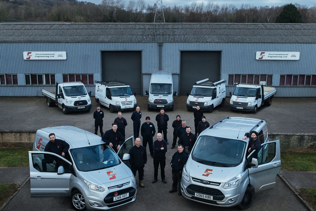two vans and a team of staff outside a factory unit