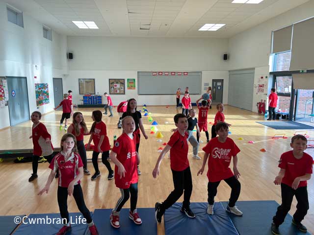 children dance in a school hall