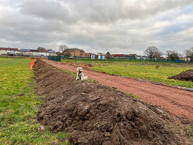 a footpath being built alongside a grass pitch