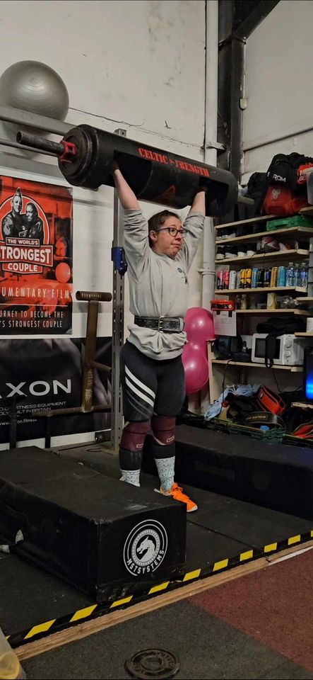 woman holds weighted bag over head