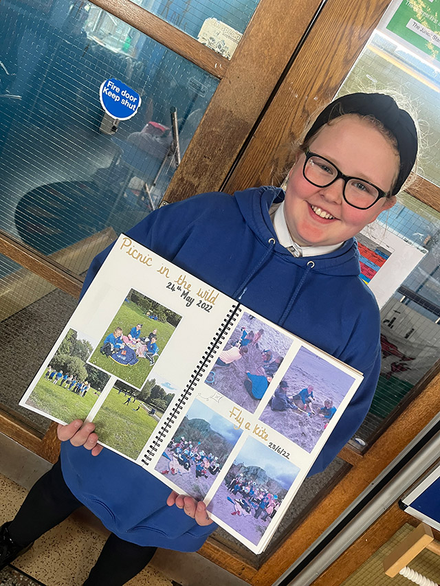 a girl holds a scrapbook