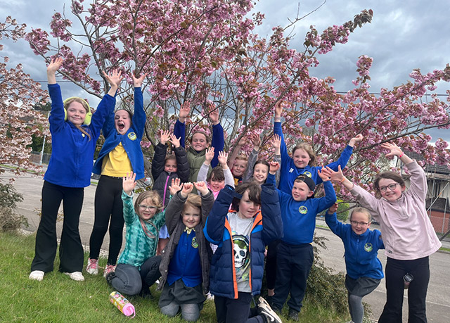 children stood by a blossom tree