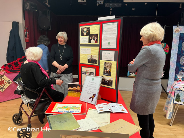 women stood by exhibition board