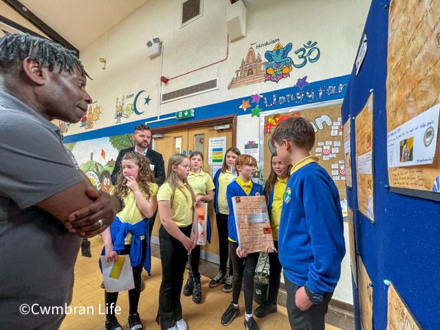 pupils stood by boards in a school