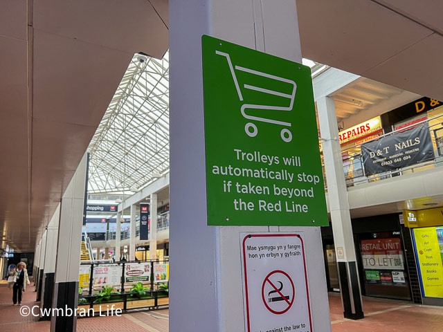 a sign warning shoppers that trolleys can't be take past this point