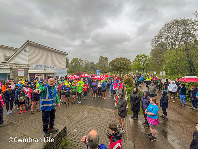 a man talks to crowd of runners at parkrun event