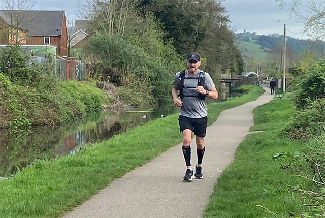 man running on path next to canal