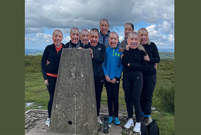 a family of nice people hold mask in front of their faces on a mountain