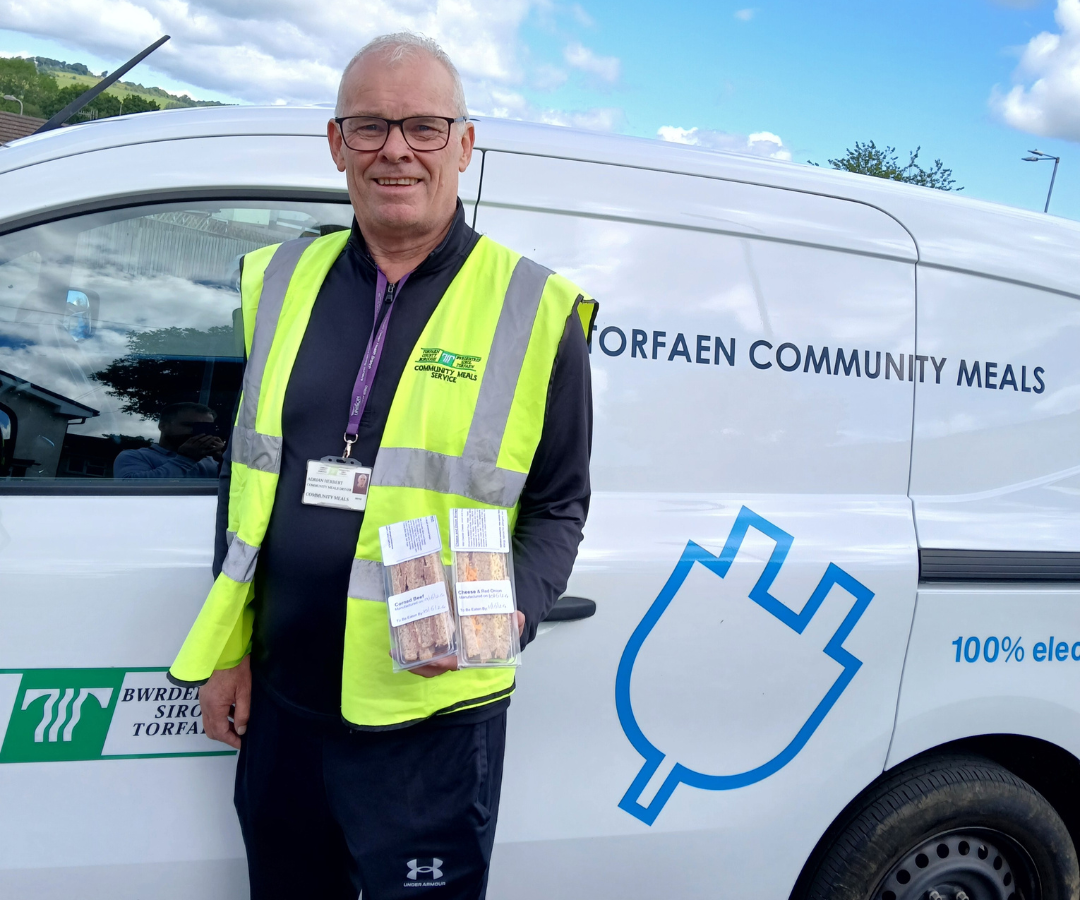 Adrian Herbert holds sandwichs stood by meals on wheels van