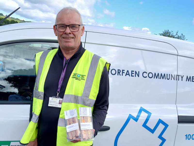 Adrian Herbert holds sandwichs stood by meals on wheels van