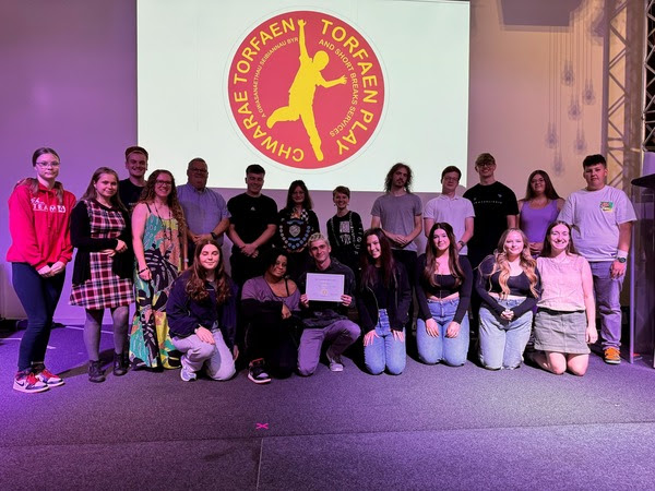 group of people hold certificates at awards event