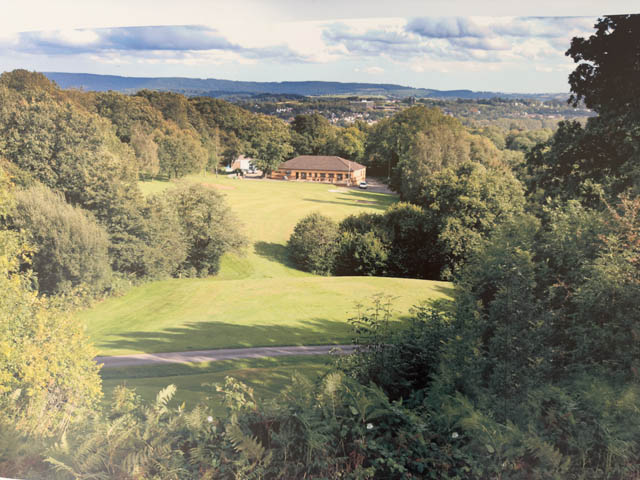 a view looking down a fairway towards a golf clubhouse