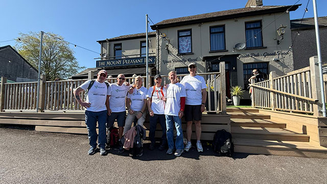 six friends stood in a row outside pub