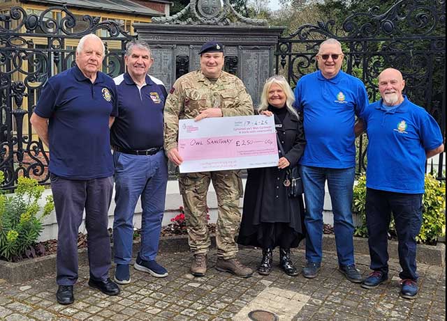 five men and a woman hold a large charity cheque
