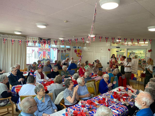 a roomfull of people celebrating VE Day at party