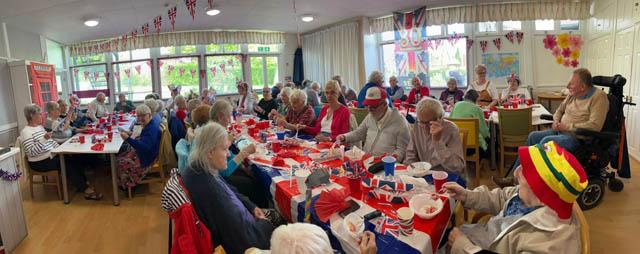 people at an indoor party to celebrate VE day with lots of union jacks