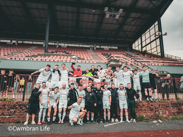 a football team celebrate holding the cup