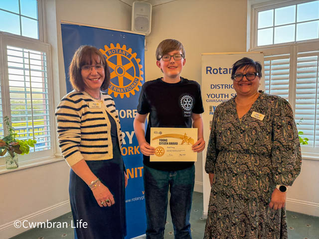 two women and a teenage boy holding a certificate