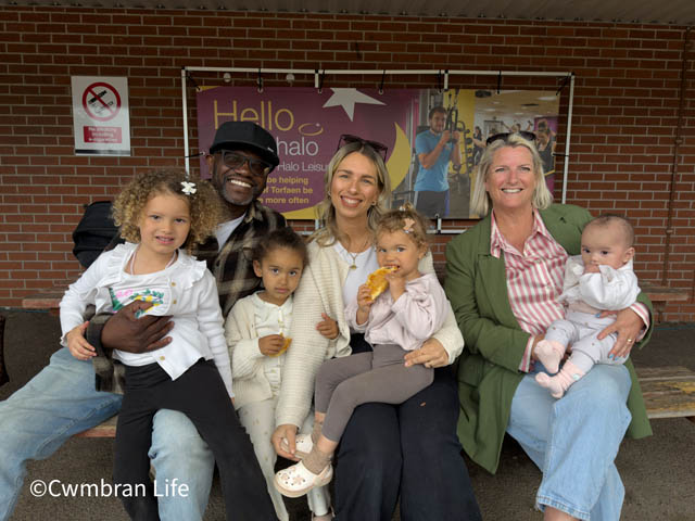three adults holding four small children